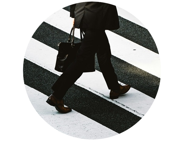businessman crossing the street wearing black suit and carrying a&nbsp;file